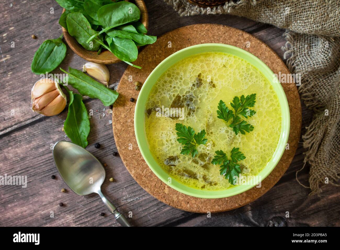 Zuppa di spinaci con panna su un rustico tavolo di legno. Vista dall'alto sfondo piatto. Foto Stock