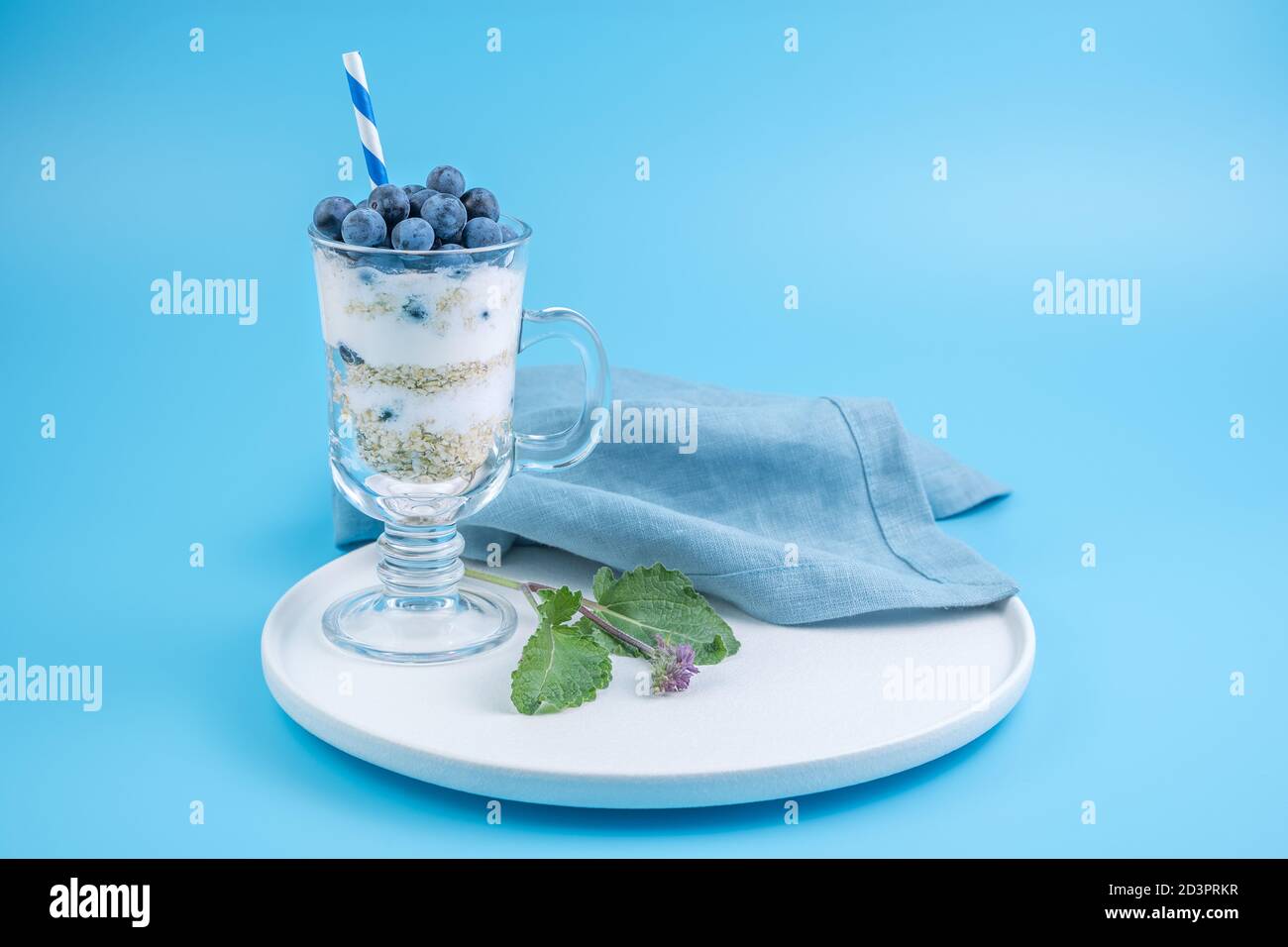 Dessert cremoso con mirtilli su uno sfondo blu morbido. Foto Stock