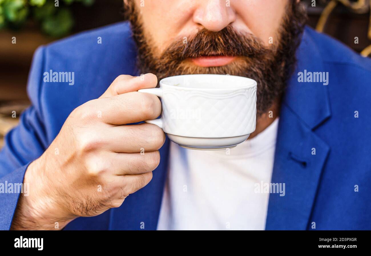 Tazza di caffè. Cappuccino e caffè espresso nero. Bevanda a base di caffè. Uomo bearded, mani che tengono una tazza calda del caffè. Tempo di coffe Foto Stock