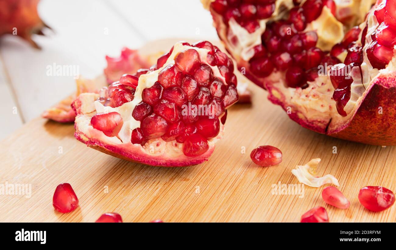 melograno rosso maturo su un tavolo di legno bianco Foto Stock