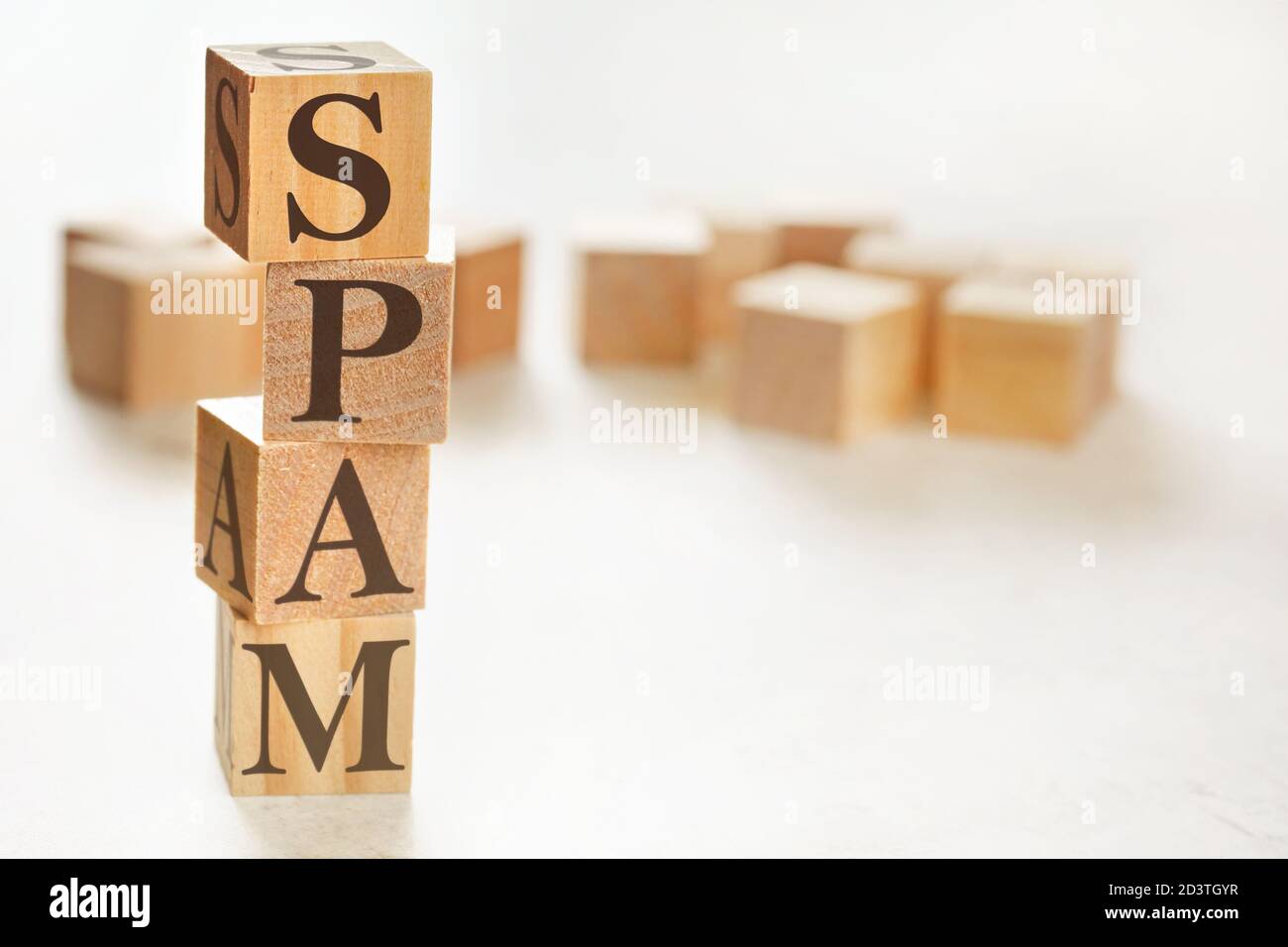 Quattro cubi di legno disposti in pila con spam di parole su di loro, spazio per testo / immagine in basso a destra angolo Foto Stock