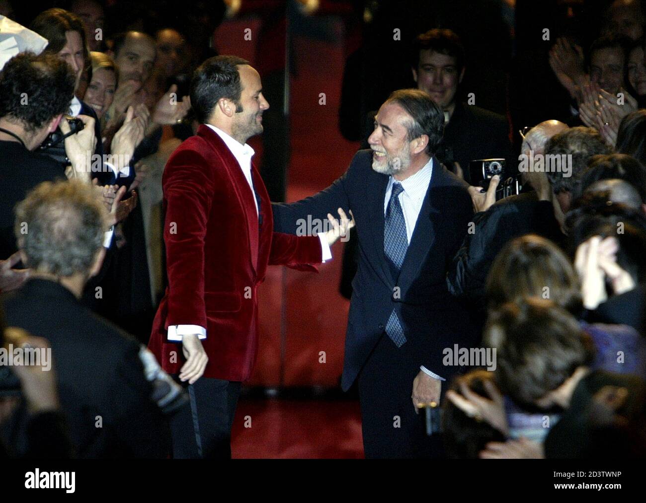 U.S. designer Tom Ford (L) salutes Gucci President delegate Domenico Del  Sole (R) at the end of French fashion house Yves Saint Laurent 2004-2005  Autumn/Winter ready-to-wear fashion collection in Paris, March 7,
