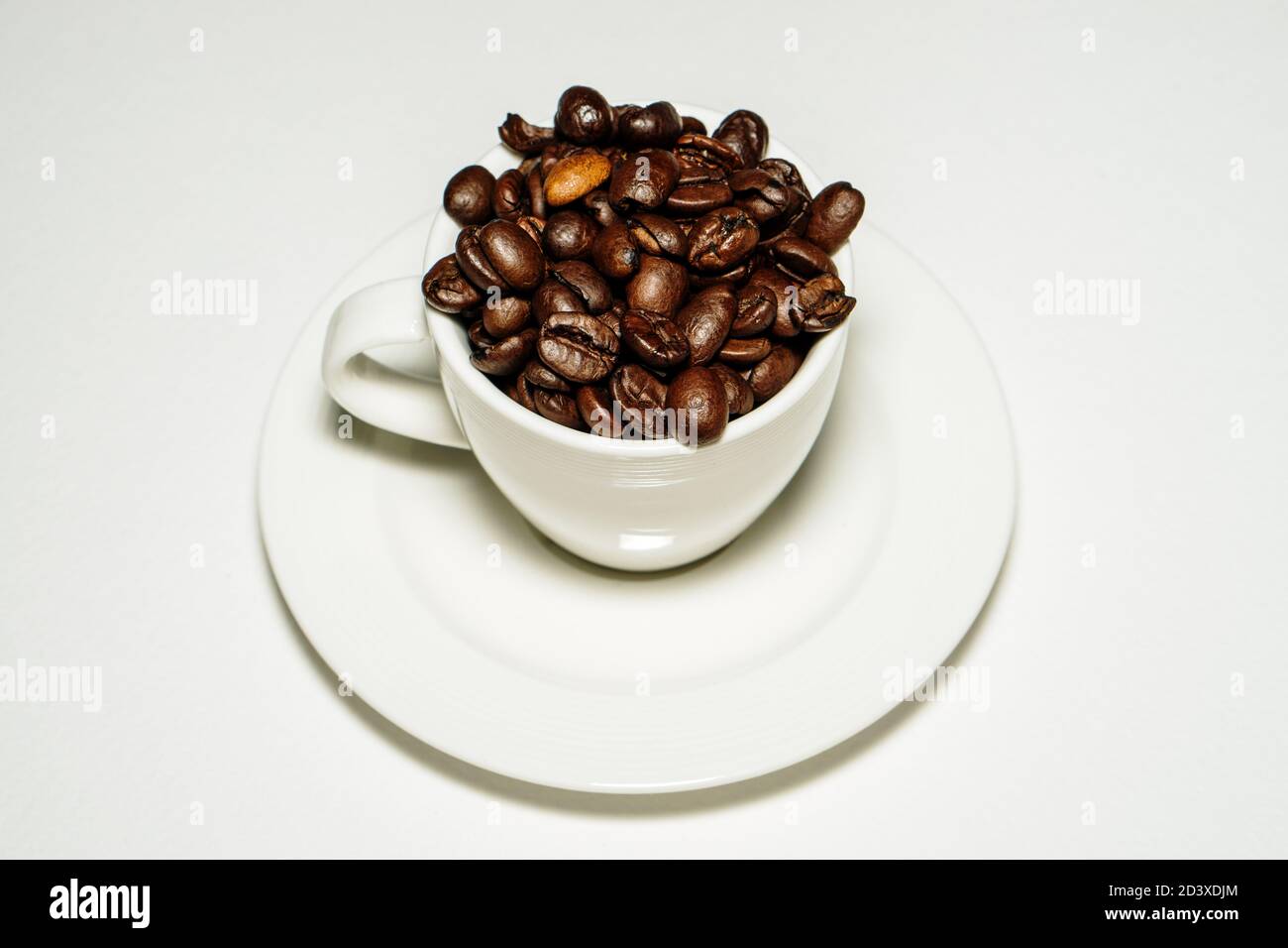 Tazza da caffè piena di chicchi di caffè Foto Stock