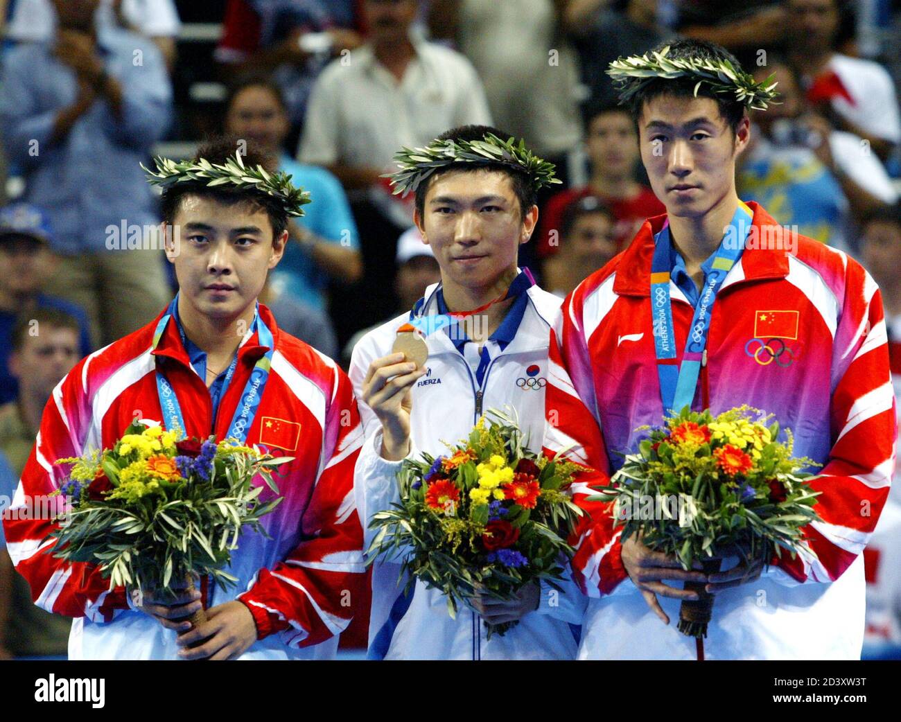 Ryu Seung min (C), medaglia d'oro della Corea del Sud, Hao Wang (L) e Liqin Wang (R), medaglia d'argento della Cina, mostrano le loro medaglie dal podio dopo la cerimonia della medaglia per l'evento maschile di ping-pong single ai Giochi Olimpici estivi di Atene 2004, 23 agosto 2004. [Ryu ha battuto Wang per vincere l'oro nella finale maschile e ha sconvolto il dominio cinese del ping-pong olimpico.] Foto Stock