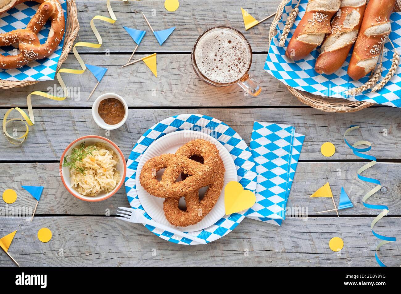 Oktoberfest cibo tradizionale, appartamento posto su tavolo di legno con decorazioni blu bianco Foto Stock