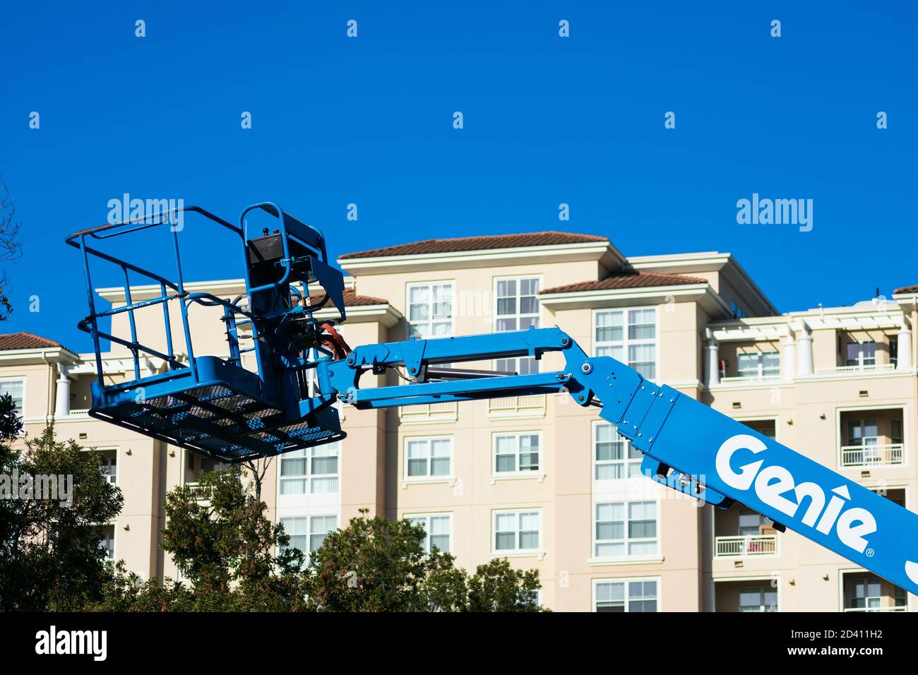 Sollevamento braccio telescopico Genie. Moderno complesso di appartamenti a più piani sullo sfondo - San Jose, California, Stati Uniti d'America - 2020 Foto Stock