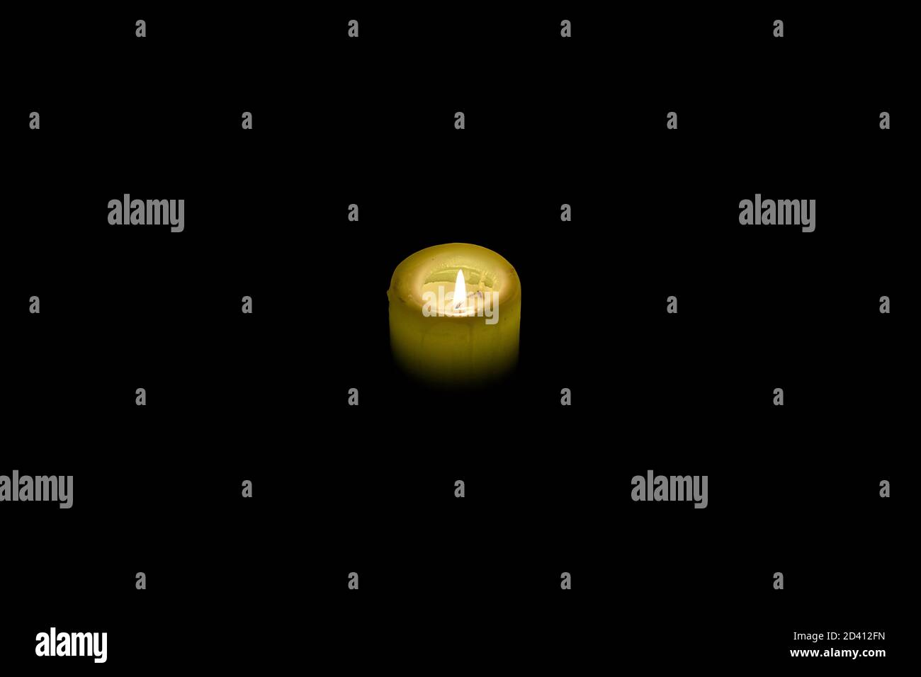 Bellissimo scatto ad alto angolo di una candela in fiamme in completo oscurità Foto Stock
