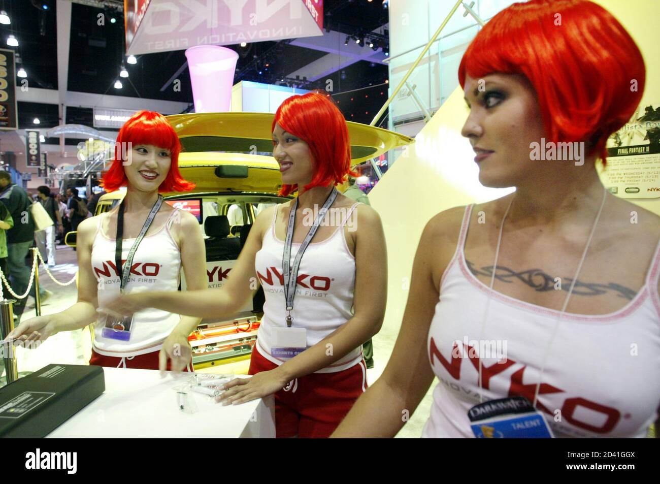 Red headed models Sindy Wei (L), Julie Anne Rose (C) and Letanya Tadlock (R) work the display for Nyko Technologies at the Electronic Entertainment Expo at the Convention Center in Los Angeles May 13, 2004. Nyko Technologies makes peripherals for interactive entertainment, personal computing and consumer electronics products. REUTERS/Robert Galbraith RG Foto Stock