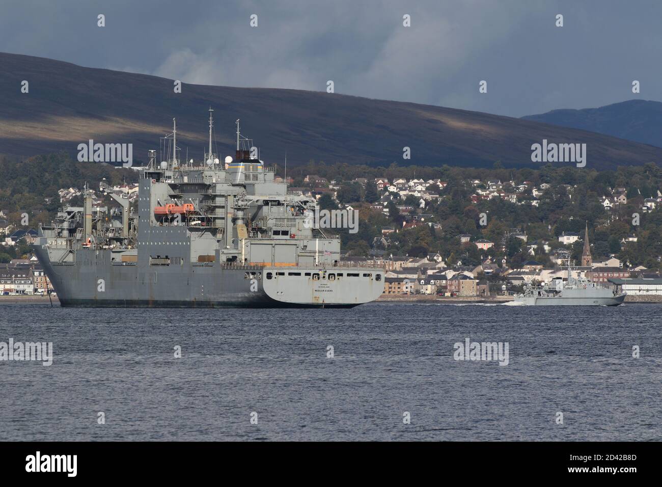 USNS Medgar Evers (T-AKE-13), una nave da carico/rifornimento secca di classe Lewis e Clark gestita dalla Marina degli Stati Uniti, all'ancora di Greenock dopo essere arrivata per l'esercizio Joint Warrior 20-2, con la Royal Navy's Sandown-class Minehunter HMS Grimsby che la passa lungo la strada per Faslane. Foto Stock