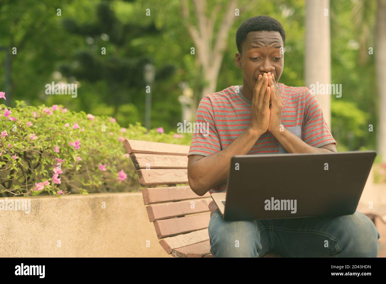 Giovane bell'uomo africano che si rilassa al parco nel città Foto Stock