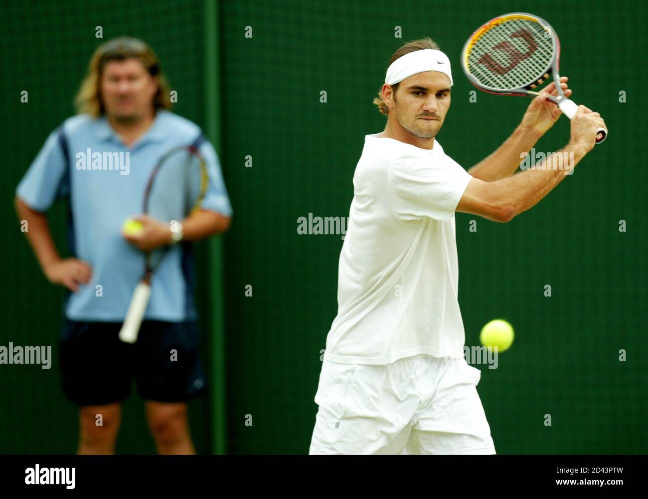 La Svizzera Roger Federer (R) pratica seguita dal suo allenatore Peter  Lundgren in vista della partita finale maschile di domenica al Wimbledon  Tennis Championships di Londra, 5 luglio 2003. Federer affronterà in
