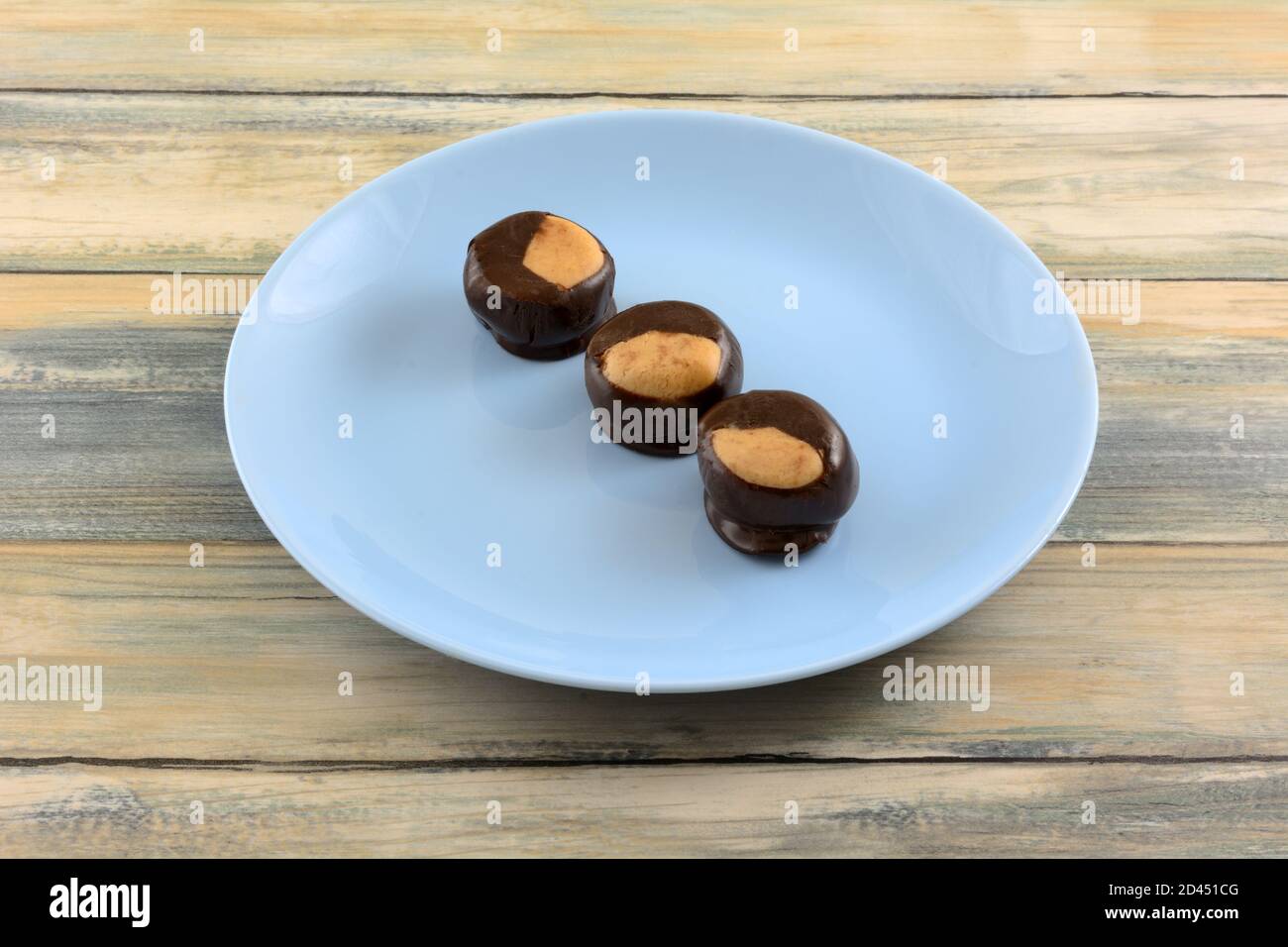 Le palle di cioccolato e burro di arachidi Buckeye spuntini su dessert blu piastra Foto Stock