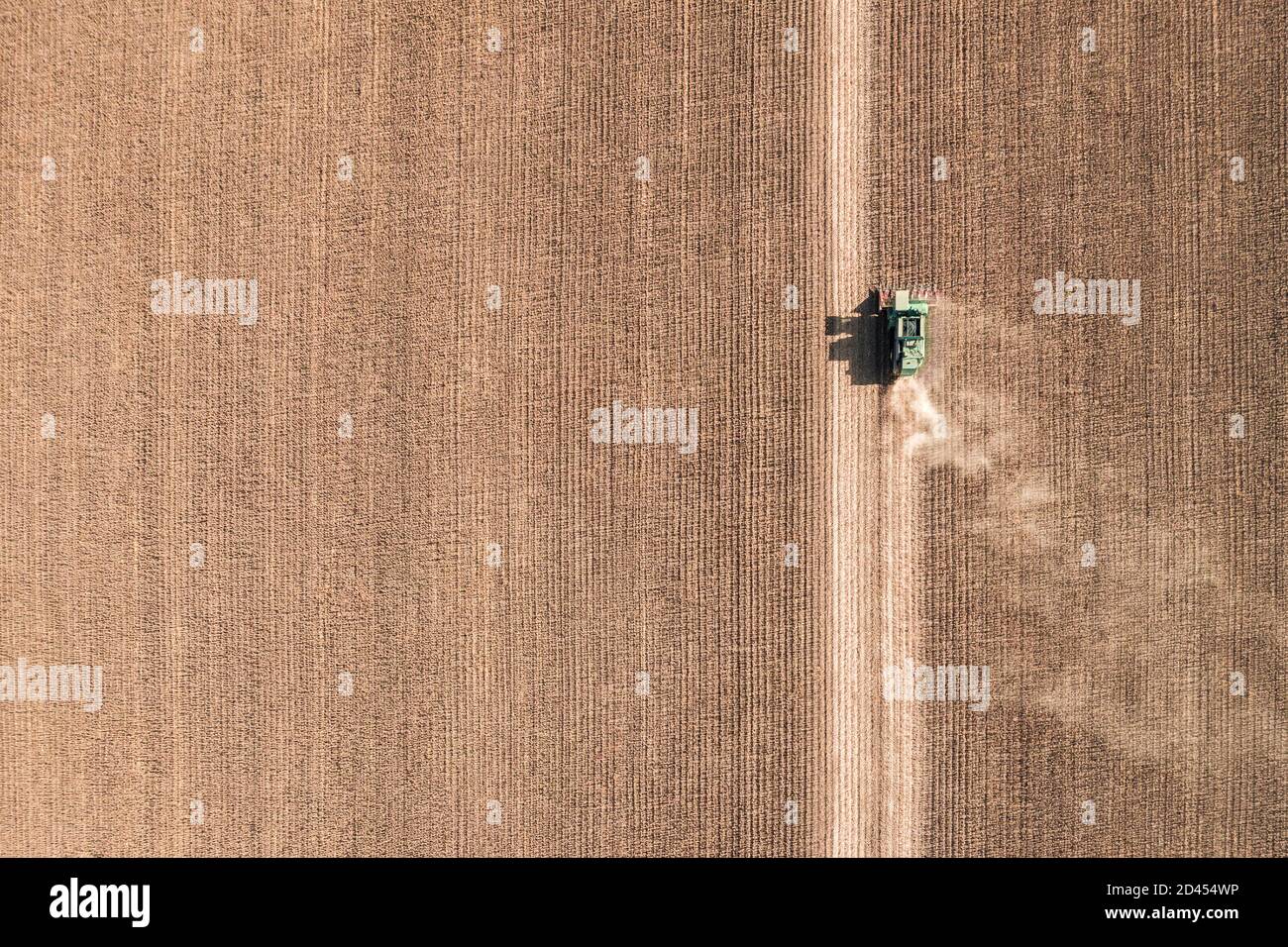 Vista aerea del drone con splendido paesaggio autunnale del trattore in funzione sul campo di raccolta. Concetto di agricoltura. Foto di alta qualità Foto Stock