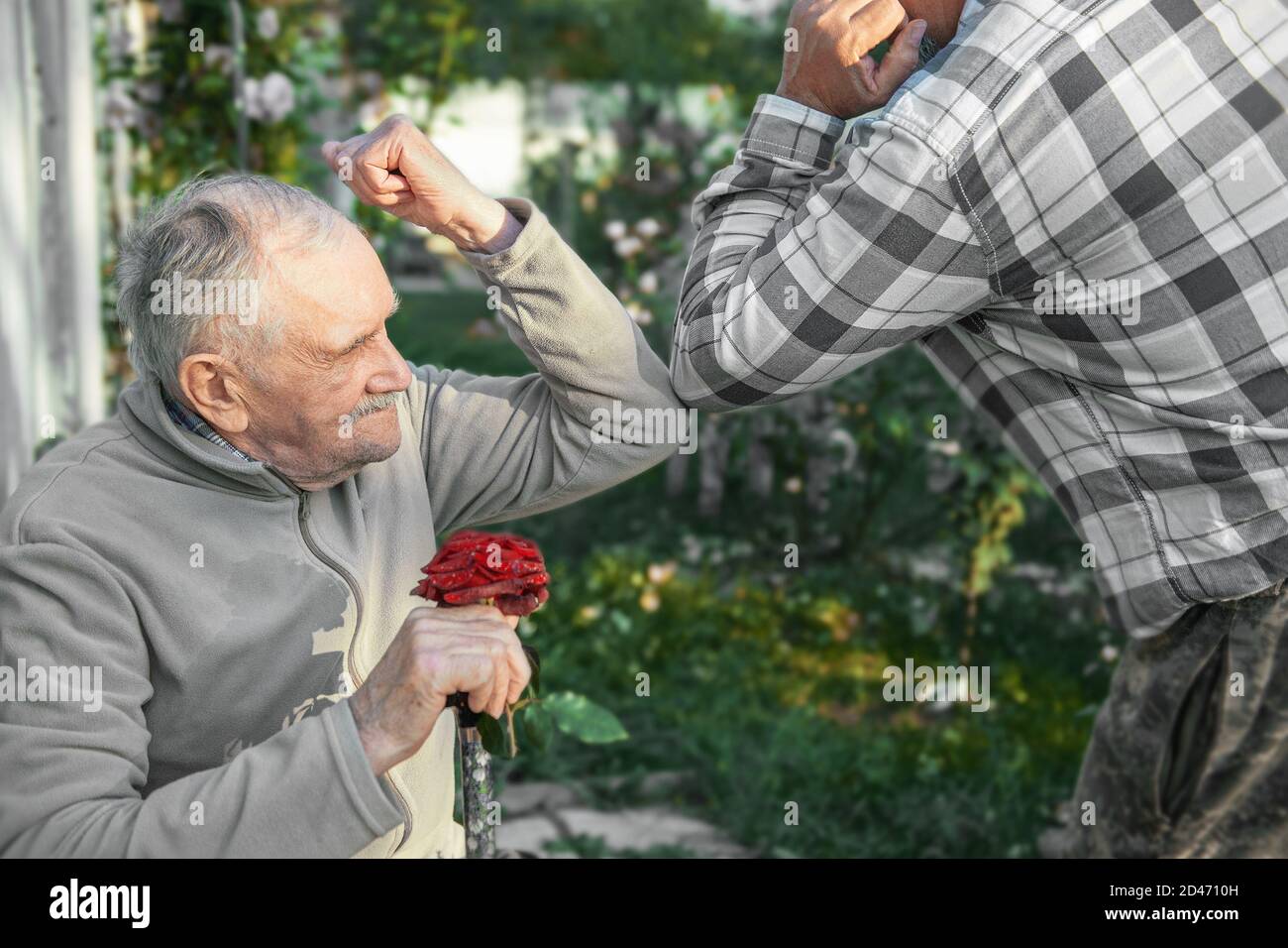 Saluto con il gomito. Un nuovo metodo di saluto per evitare la diffusione del coronavirus COVID-19. Il vecchio e suo figlio si sono arenati i gomiti invece di Foto Stock
