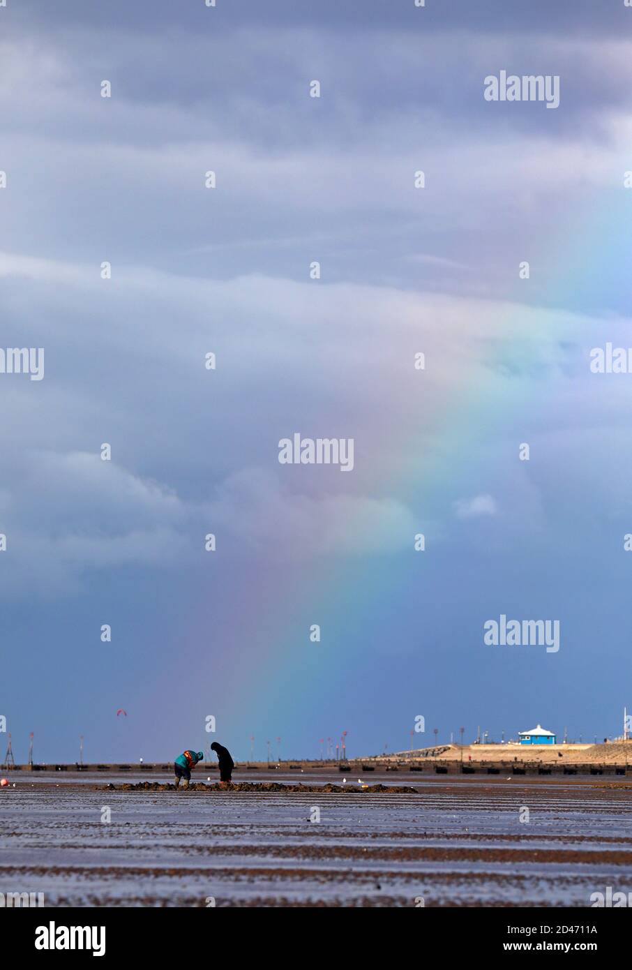 Heacham, Regno Unito. 06 ottobre 2020. Le persone che scavano per l'esca di pesca sono evidenziate da un arcobaleno a Heacham, Norfolk, Regno Unito, il 6 ottobre 2020. Credit: Paul Marriott/Alamy Live News Foto Stock