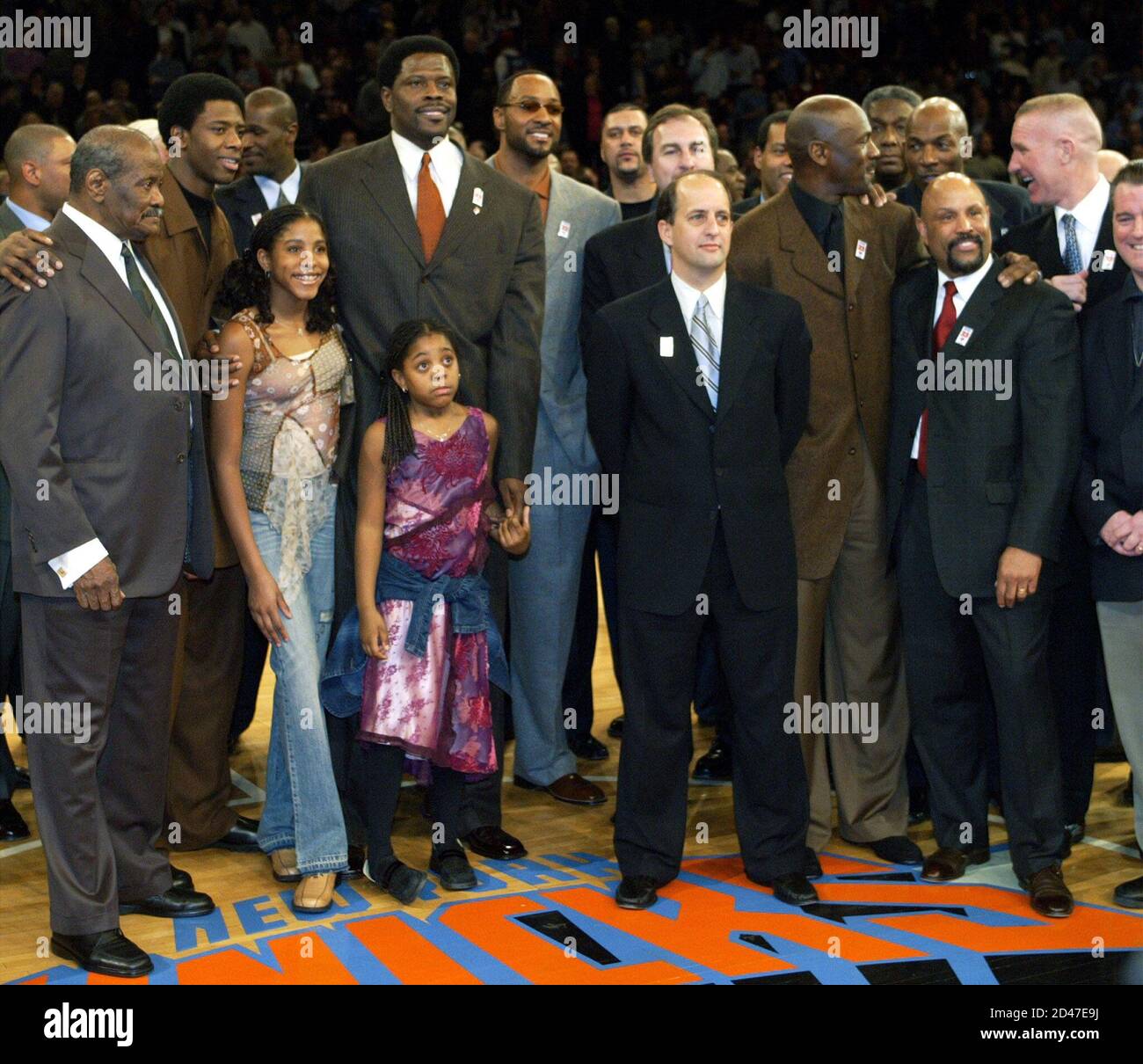 Il centro in pensione di New York Knicks Patrick Ewing è circondato da  parenti e amici dopo aver innalzato il suo numero uniforme al soffitto  durante le cerimonie di metà tempo durante
