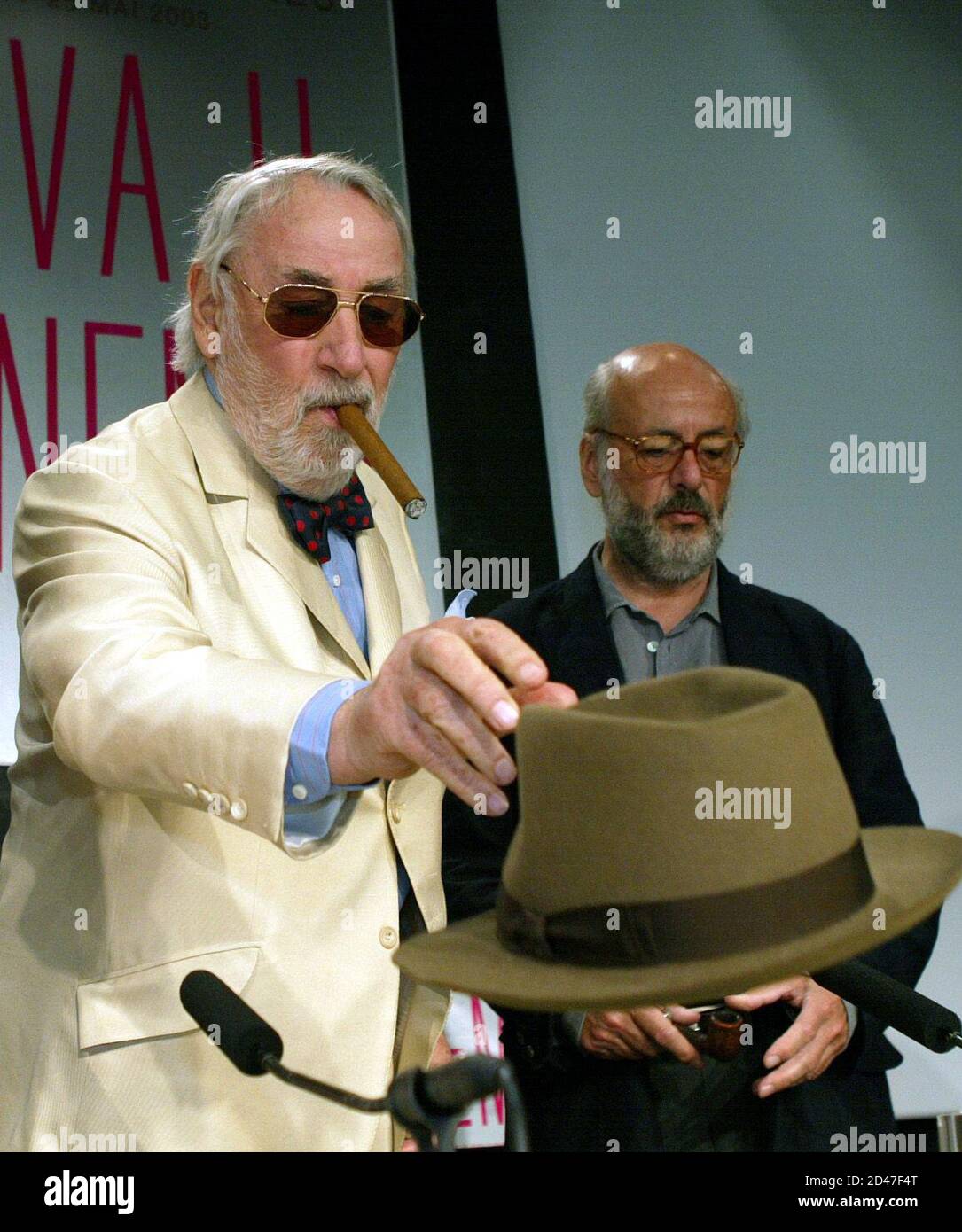 L'attore francese Philippe Noiret (L) toglie il cappello mentre fuma un  sigaro quando arriva con il regista francese Bertrand Blier (R REAR) per  una conferenza stampa 'Les Cotelettes' al 56° Festival Internazionale