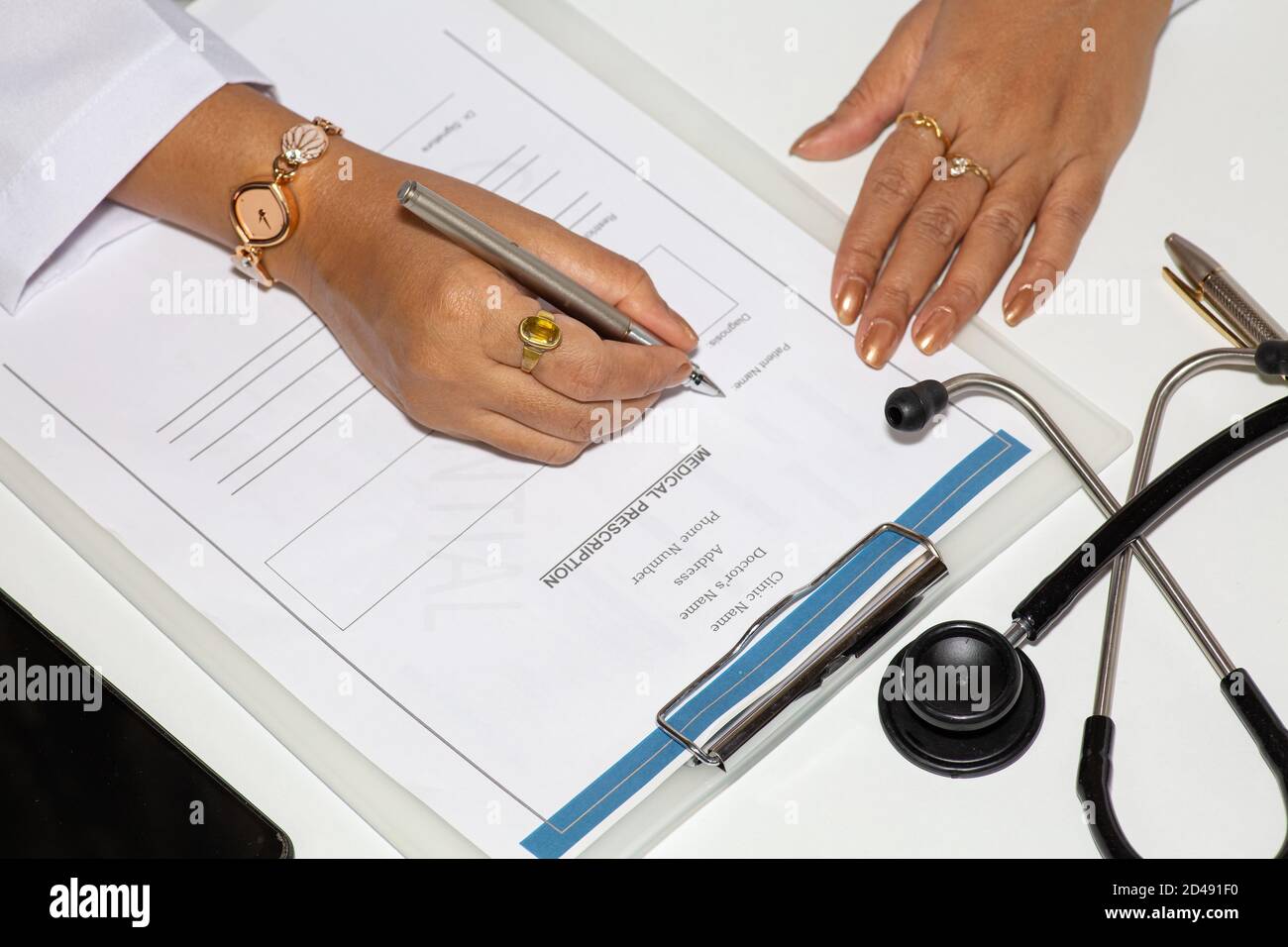 Medico femminile che scrive una forma di prescrizione medica con bottiglie di vaccino sul tavolo Foto Stock