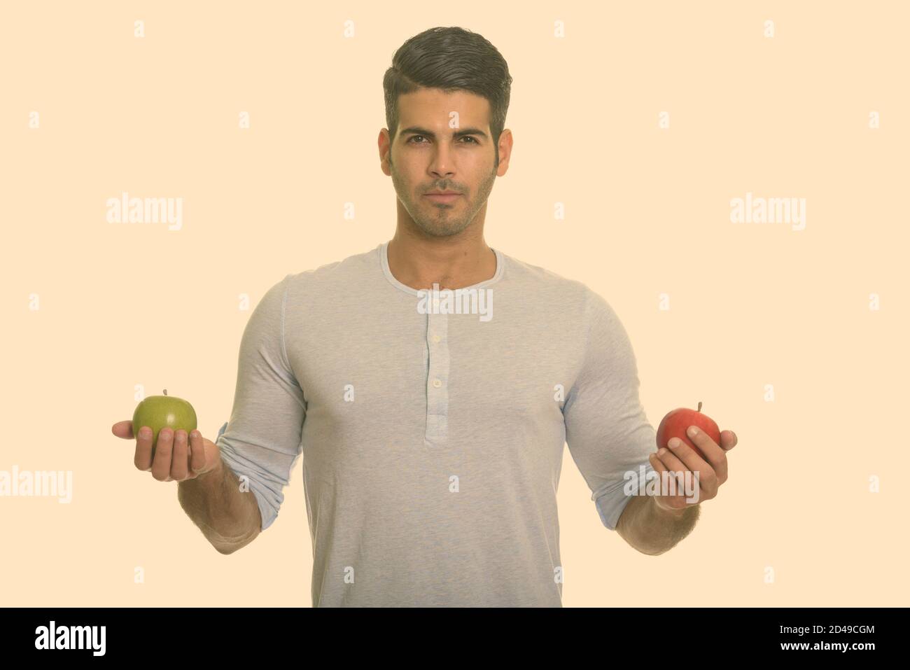 Bel giovane uomo persiano holding rosso e verde mela Foto Stock