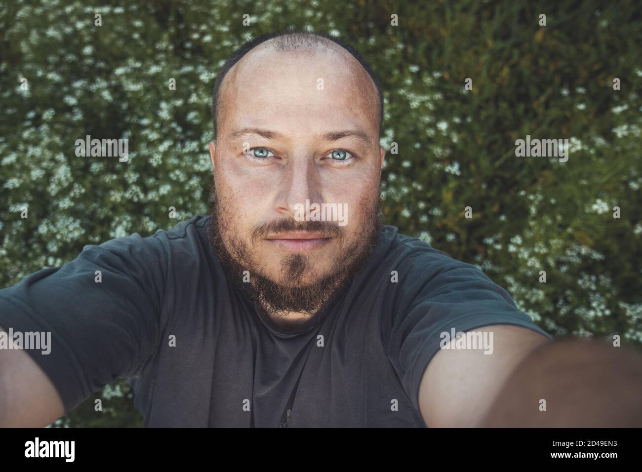 Uomo europeo con una barba che raggiunge la fotocamera Foto Stock