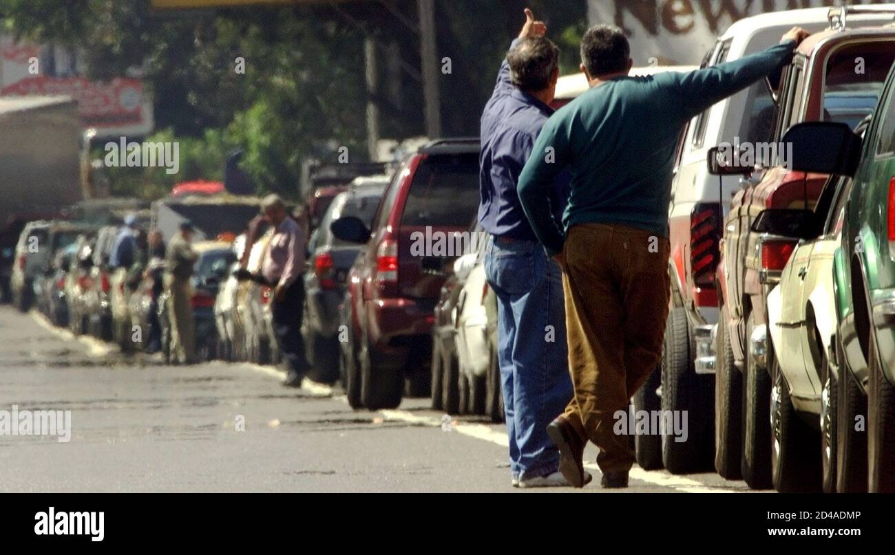 Uomini venezuelani aspettano in una vasta linea di auto in attesa di acquistare benzina a Caracas Venezuela, 26 dicembre 2002. I venezuelani soffrono di carenze di benzina nella quarta settimana di sciopero che ha ridotto la produzione di petrolio e ridotto le esportazioni da parte dell'esportatore mondiale di petrolio n.5. REUTERS/Jorge Silva JS Foto Stock
