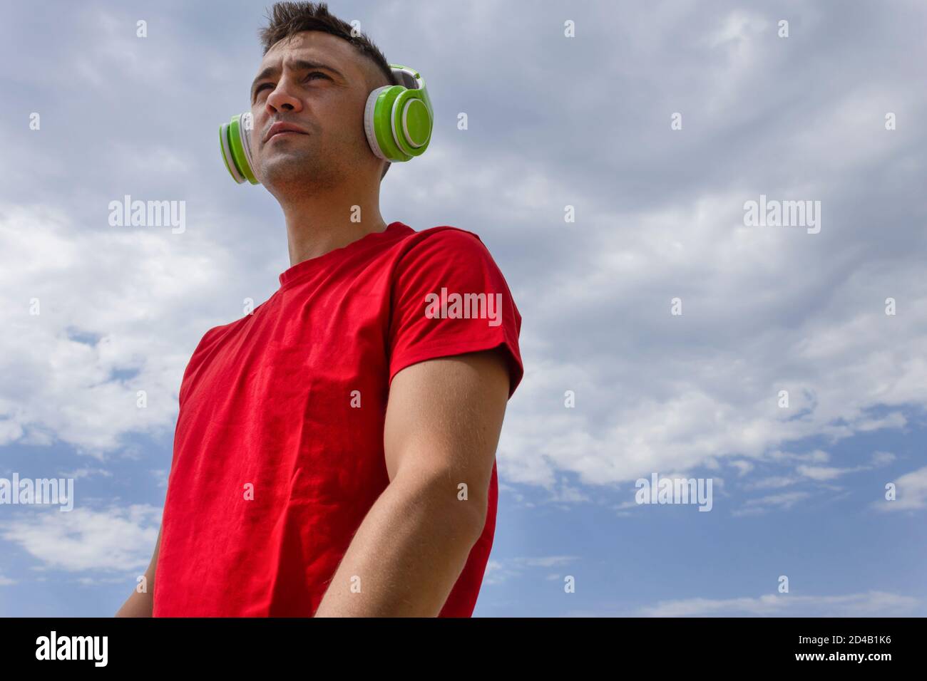 Un uomo serio che guarda la musica con orizzonte sulle cuffie .Lifestyle Concept Hope, nuovi orizzonti. Foto Stock