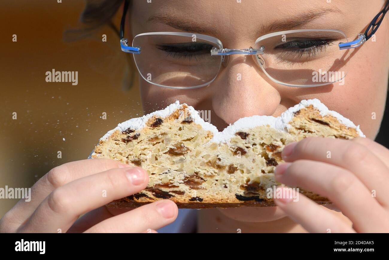 Dresda, Germania. 8 ottobre 2020. Johanna Meitzner, la 26a Dresden Stollen Girl, odora un pezzo di Stollen di Natale durante la sua esibizione nel Pillnitz Palace Park. L'apprendista fornaio di 21 anni è l'ambasciatore dello Stollen di Natale di Dresda per la durata di un anno a nome dei Dresden Stollen Bakers. Credit: Robert Michael/dpa-Zentralbild/ZB/dpa/Alamy Live News Foto Stock