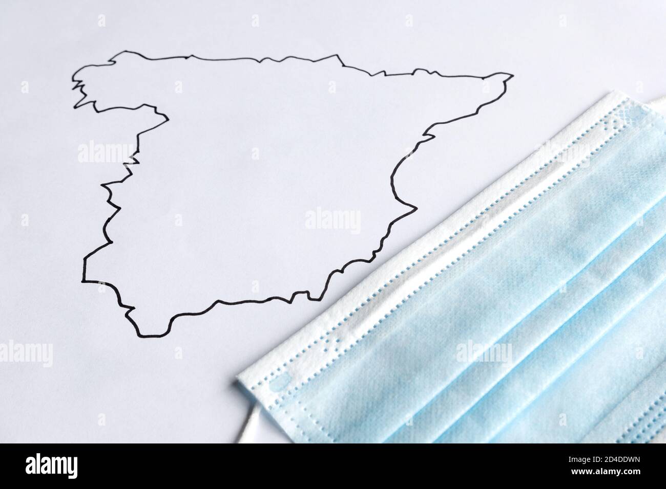 Mappa della spagna disegnata su un foglio bianco con una covid-19 maschera coronavirus Foto Stock