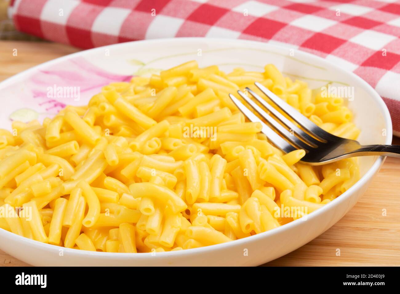 Piatto pieno di deliziosi Macaroni e formaggio su un legno sfondo Foto Stock
