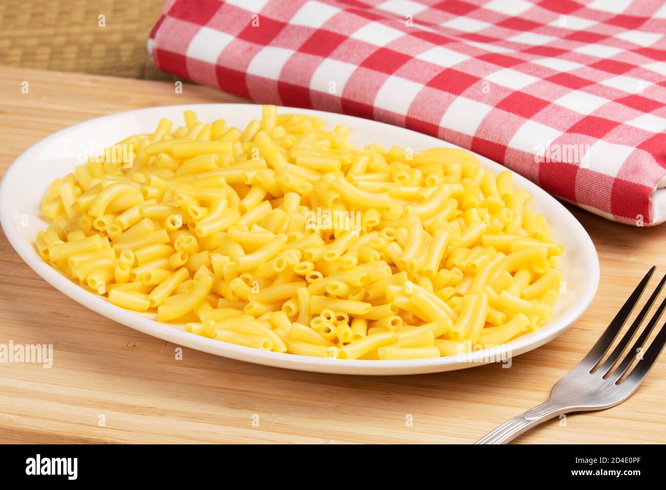 Piatto pieno di deliziosi Macaroni e formaggio su un legno sfondo Foto Stock