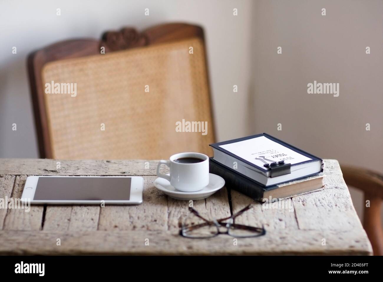 Un tranquillo spazio per l'ufficio domestico con elementi naturali sostenibili come la sedia di rattan o di canna e un legno recuperato scrivania Foto Stock