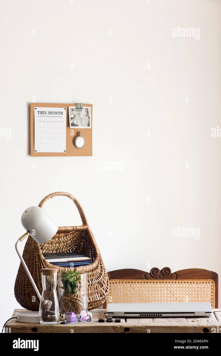 Un tranquillo ufficio domestico decorato con elementi naturali sostenibili di decor (come piante, rattan, canna, sughero e iuta) e una scrivania di legno rigenerata Foto Stock