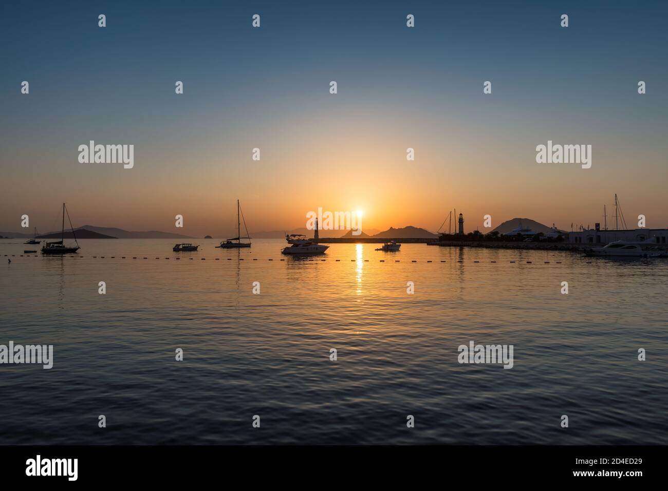 Faro al tramonto nel porto Foto Stock