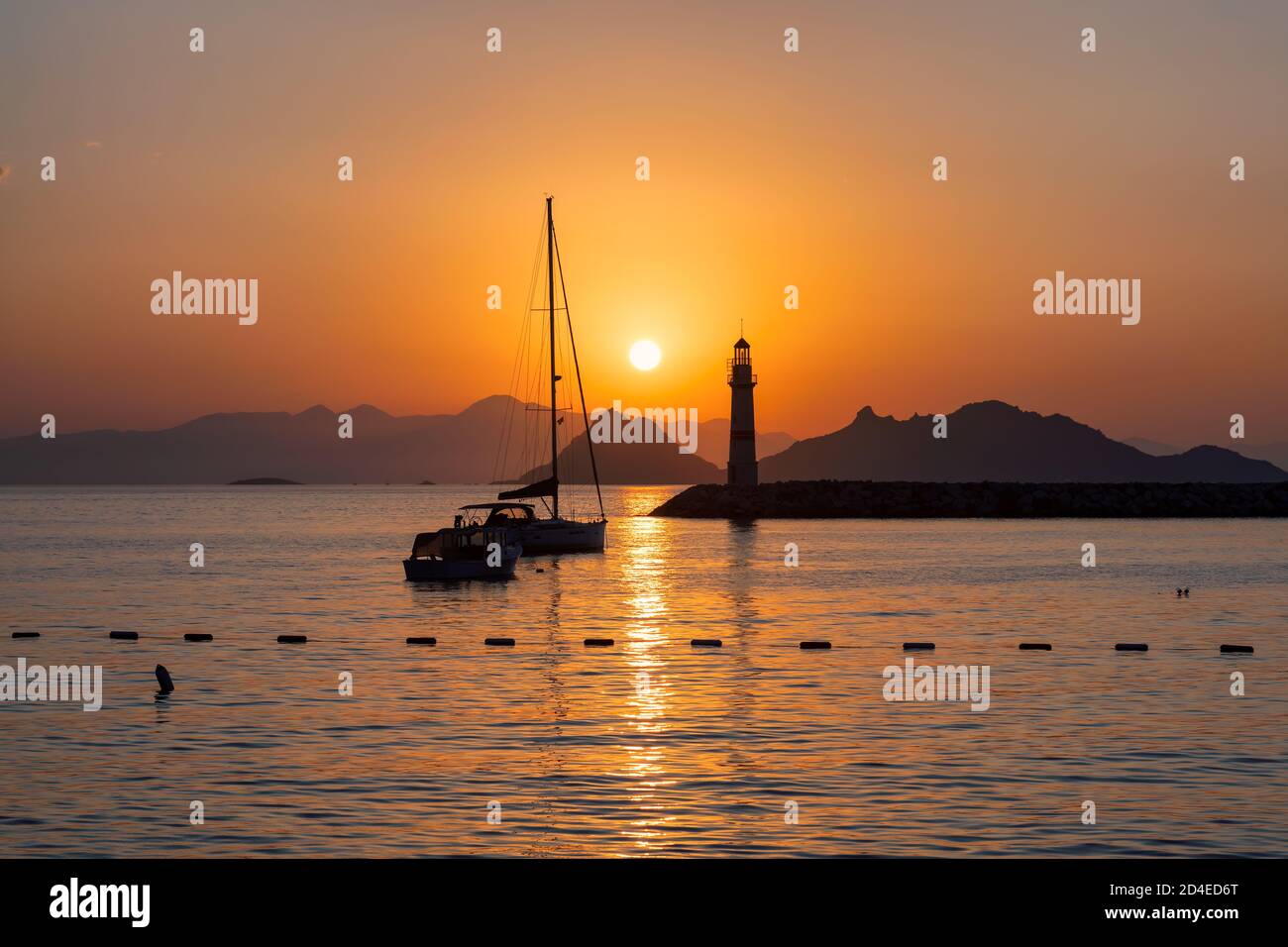 Faro al tramonto nel porto Foto Stock