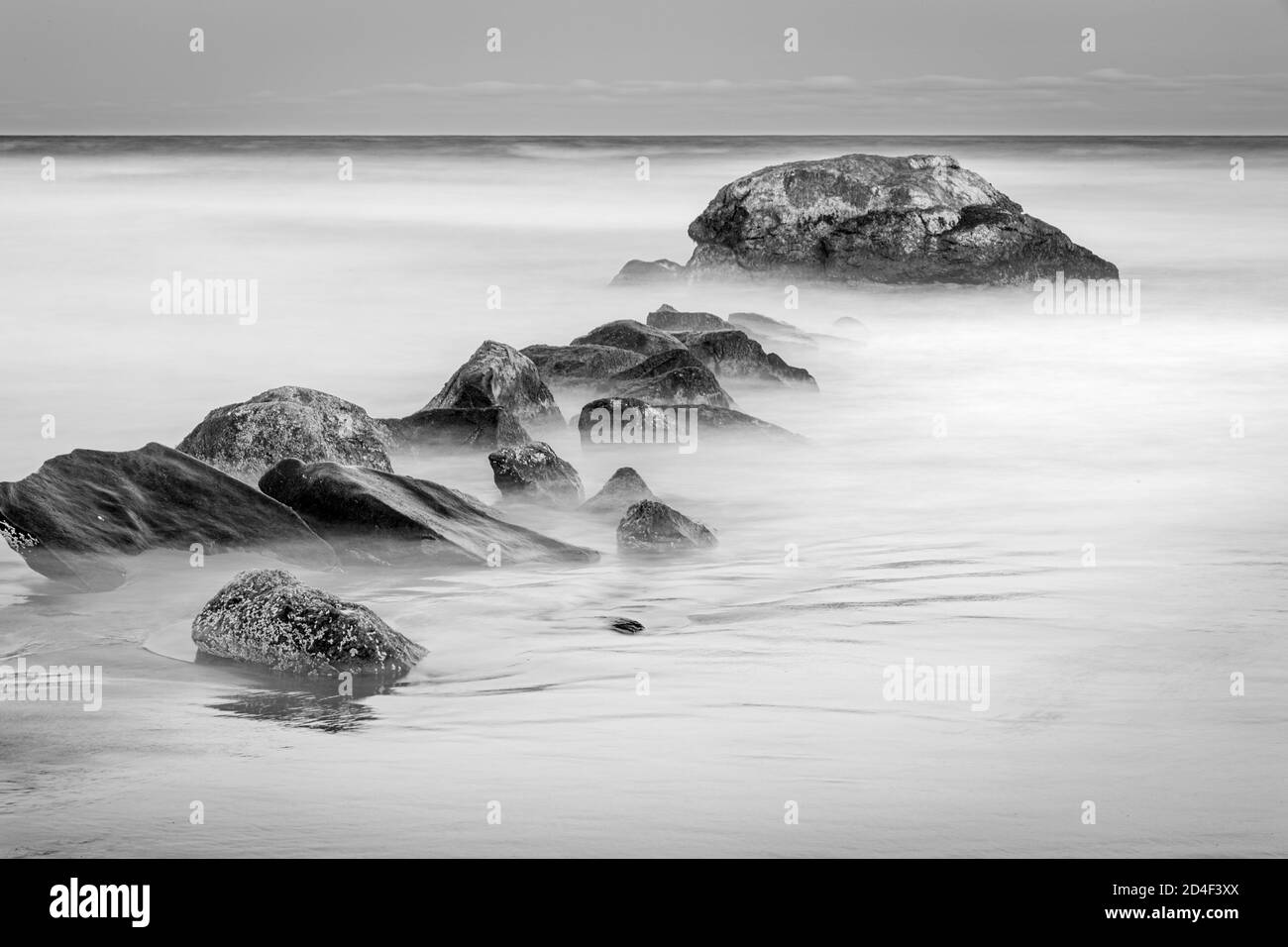 Misty onde sfocate e surf con rocce all'alba, Narragansett, Rhode Island USA Foto Stock