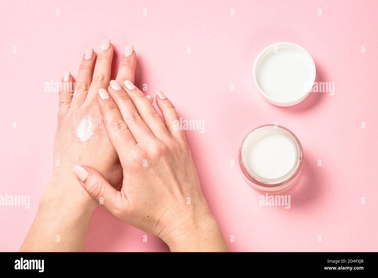 Donna che utilizza la crema per le mani. Foto Stock