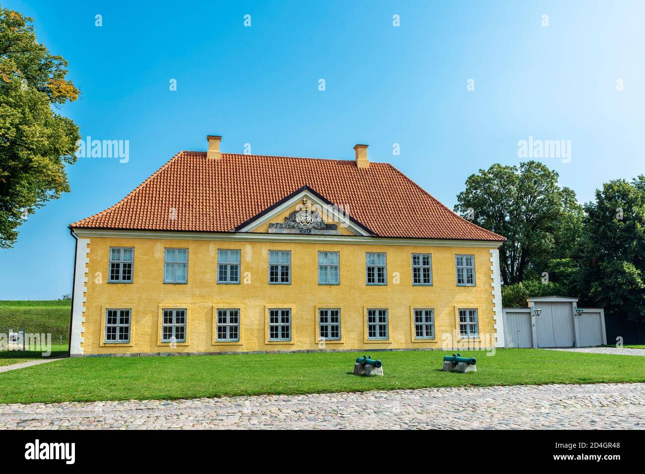 Facciata della Casa del Comandante con due vecchi cannoni a Kastellet (la Cittadella), Copenhagen, Danimarca Foto Stock