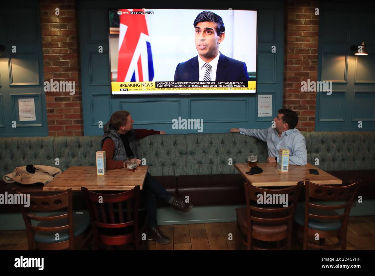 I clienti della Tib Street Tavern a Manchester guardano come il Cancelliere dello scacchiere Rishi Sunak annuncia che il governo pagherà due terzi dei salari del personale in pub, ristoranti e altre imprese se sono costretti a chiudere sotto nuove restrizioni coronavirus. Le città nel nord dell'Inghilterra e in altre zone che soffrono un'impennata in casi di Covid-19 possono avere pub e ristoranti temporaneamente chiusi per combattere la diffusione del virus. Foto Stock