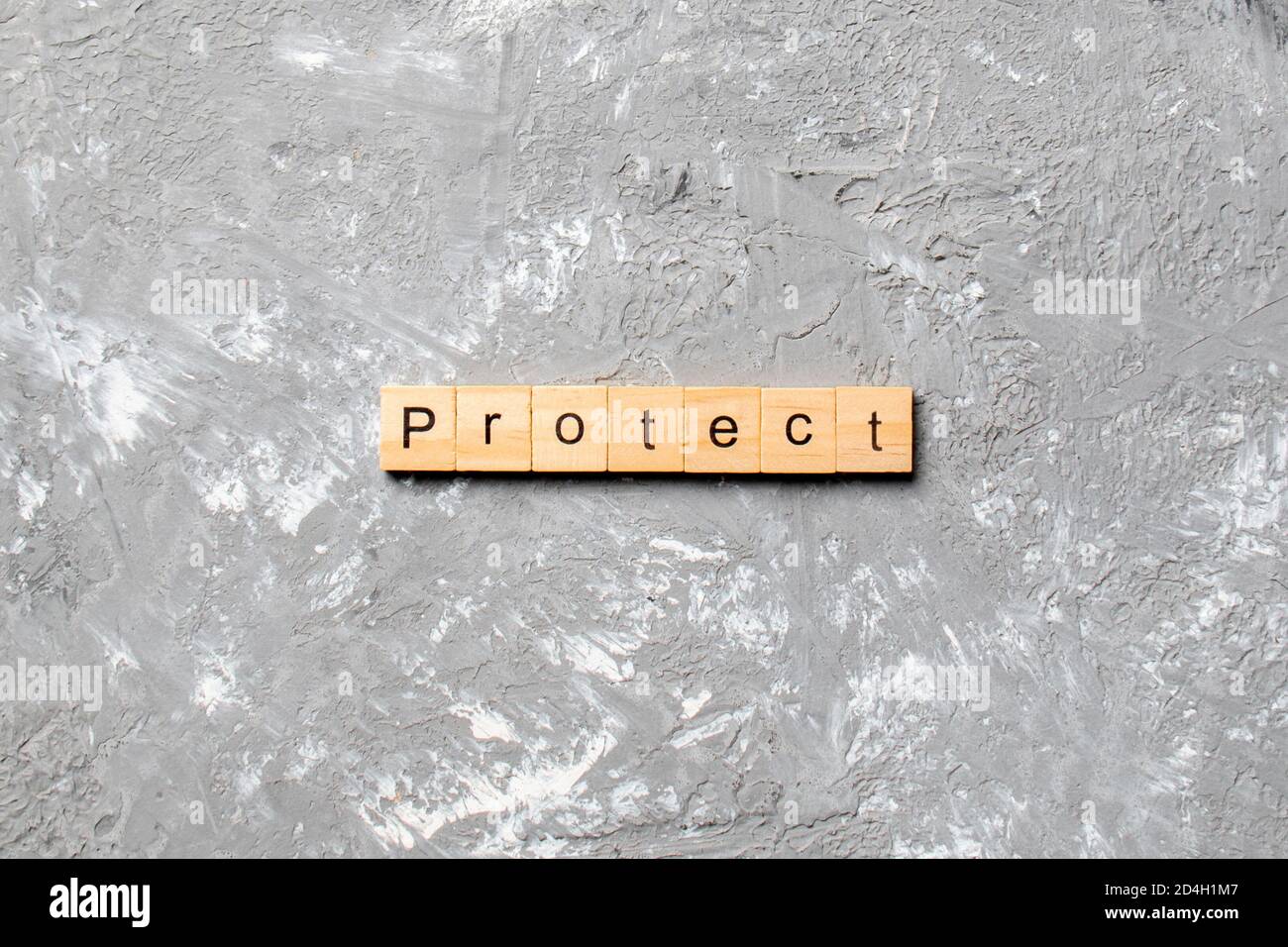 PROTEGGERE la parola scritta sul blocco di legno. PROTEGGA il testo sulla tabella di cemento per il vostro desing, concetto. Foto Stock