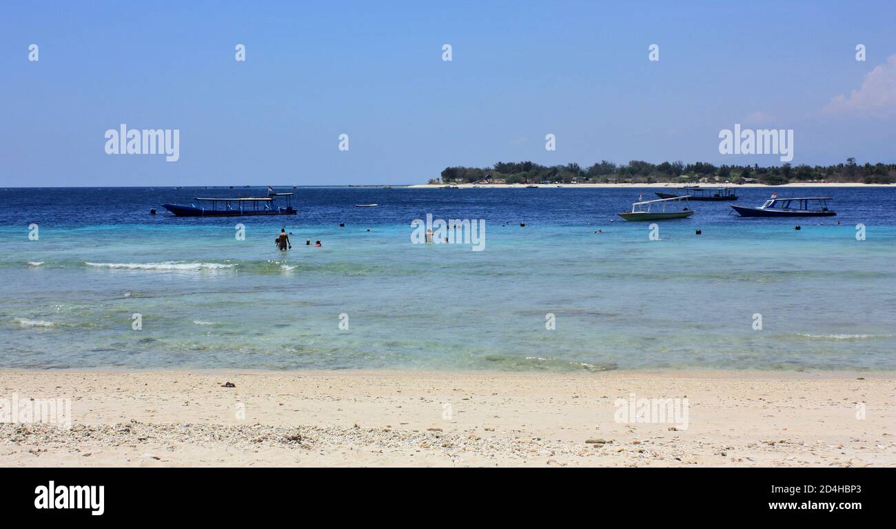 Vista verso est attraverso le acque blu limpide verso Gili meno, foto scattata sulla spiaggia di Gili Trawangan, Indonesia Foto Stock