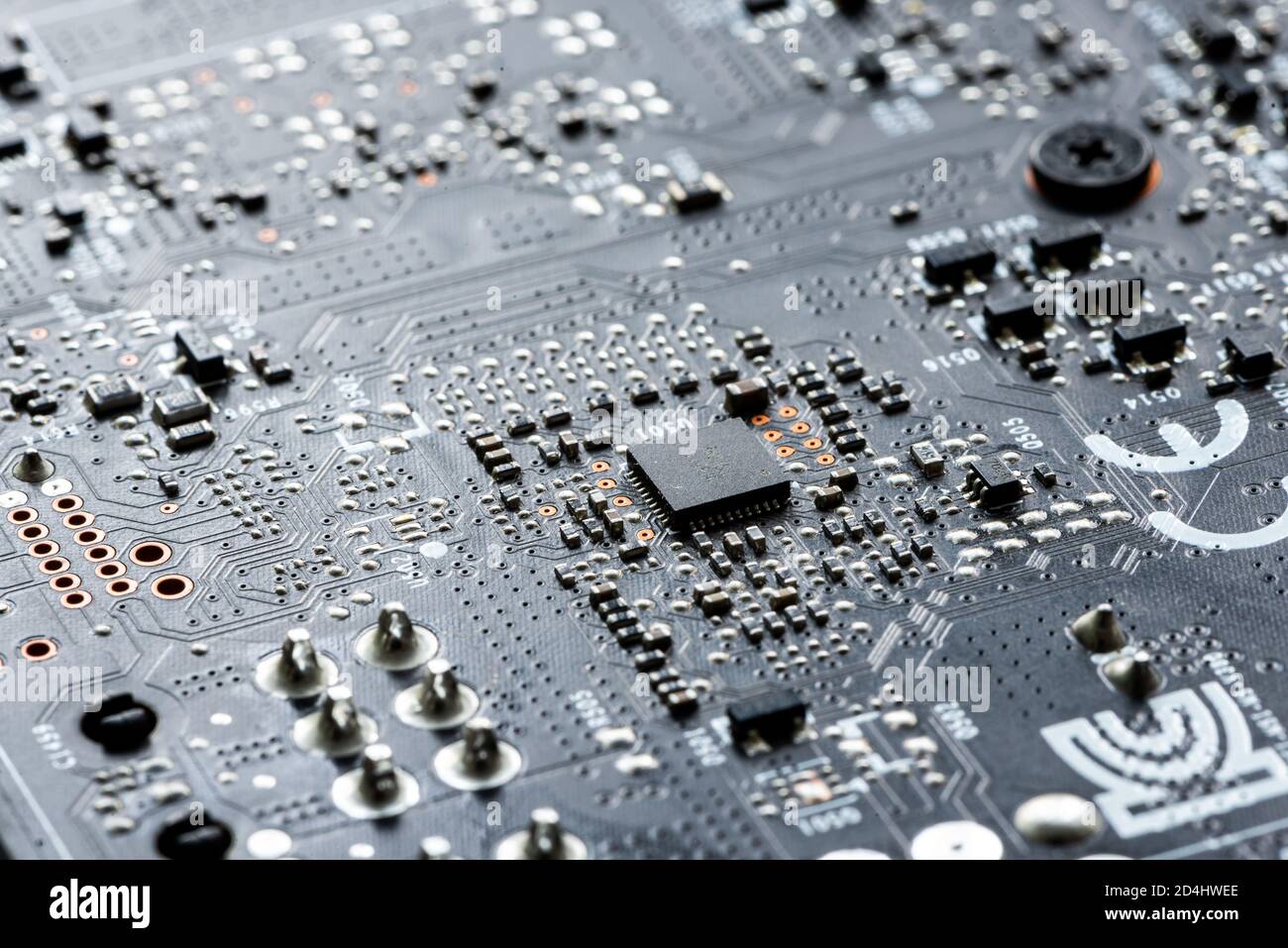 Scheda a circuito stampato per circuito stampato elettronico in macro-close-up con circuiti a transistor ed elementi hardware elettrici, chip di computer visibili Foto Stock