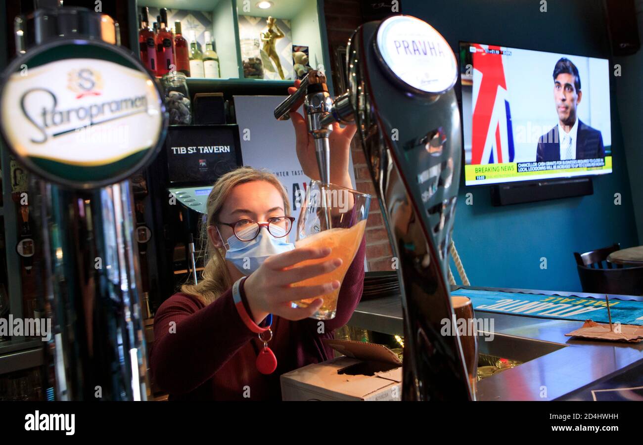 Un dipendente tira una pinta nella Tib Street Tavern a Manchester, come il Cancelliere dello scacchiere Rishi Sunak annuncia che il governo pagherà due terzi dei salari del personale in pub, ristoranti e altre imprese, se sono costretti a chiudere sotto nuove restrizioni coronavirus. Le città nel nord dell'Inghilterra e in altre zone che soffrono un'impennata in casi di Covid-19 possono avere pub e ristoranti temporaneamente chiusi per combattere la diffusione del virus. Foto Stock