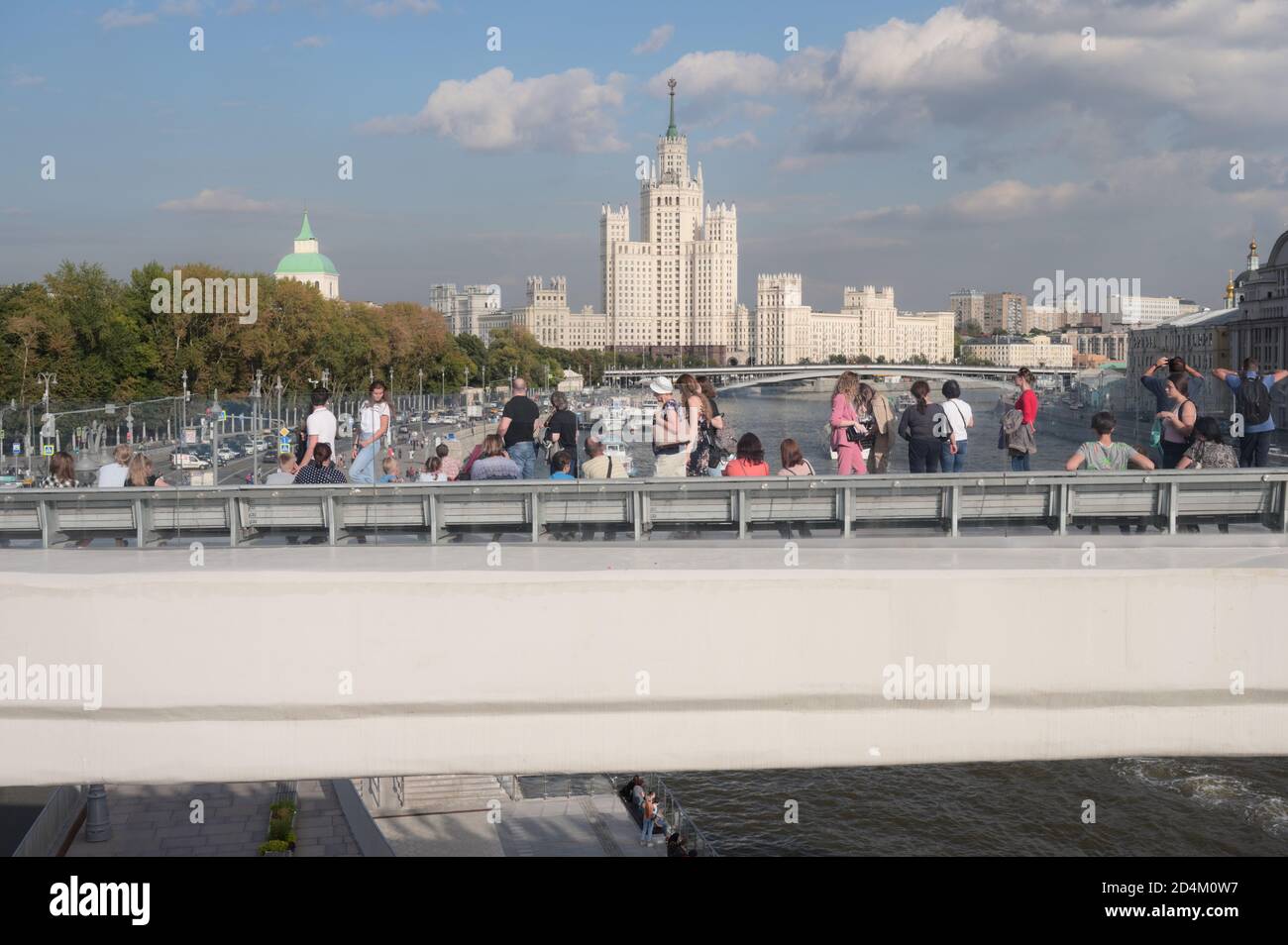 I turisti sul fiume si affacciano, 70 metri di lunghezza console in cemento nel parco Zaryadye nel centro di Mosca, Russia, contro uno dei sette grattacieli Suore Foto Stock
