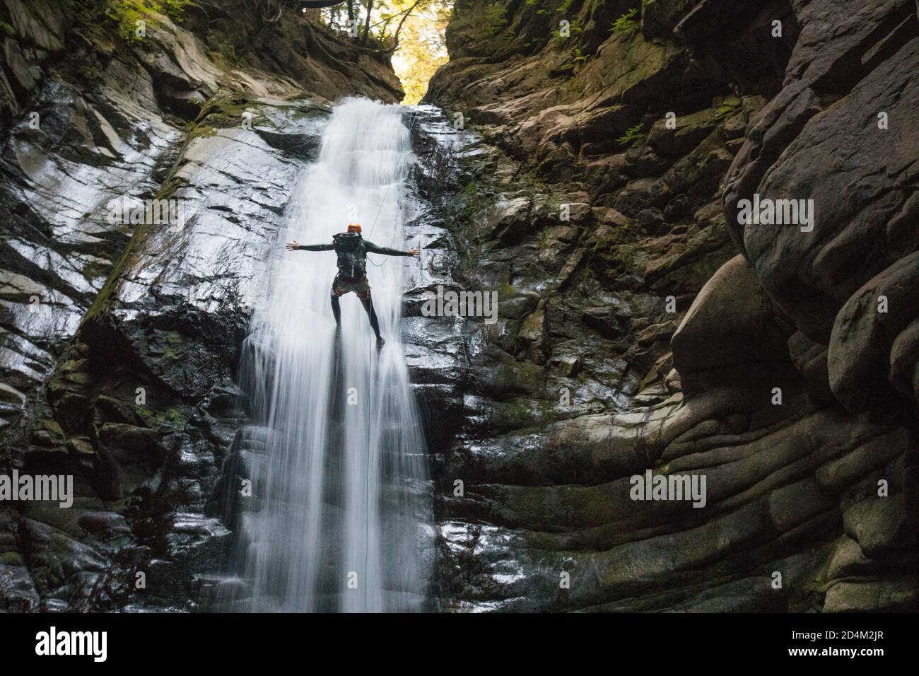 Nessuna mano mentre si rappelling nel mezzo di una cascata. Foto Stock
