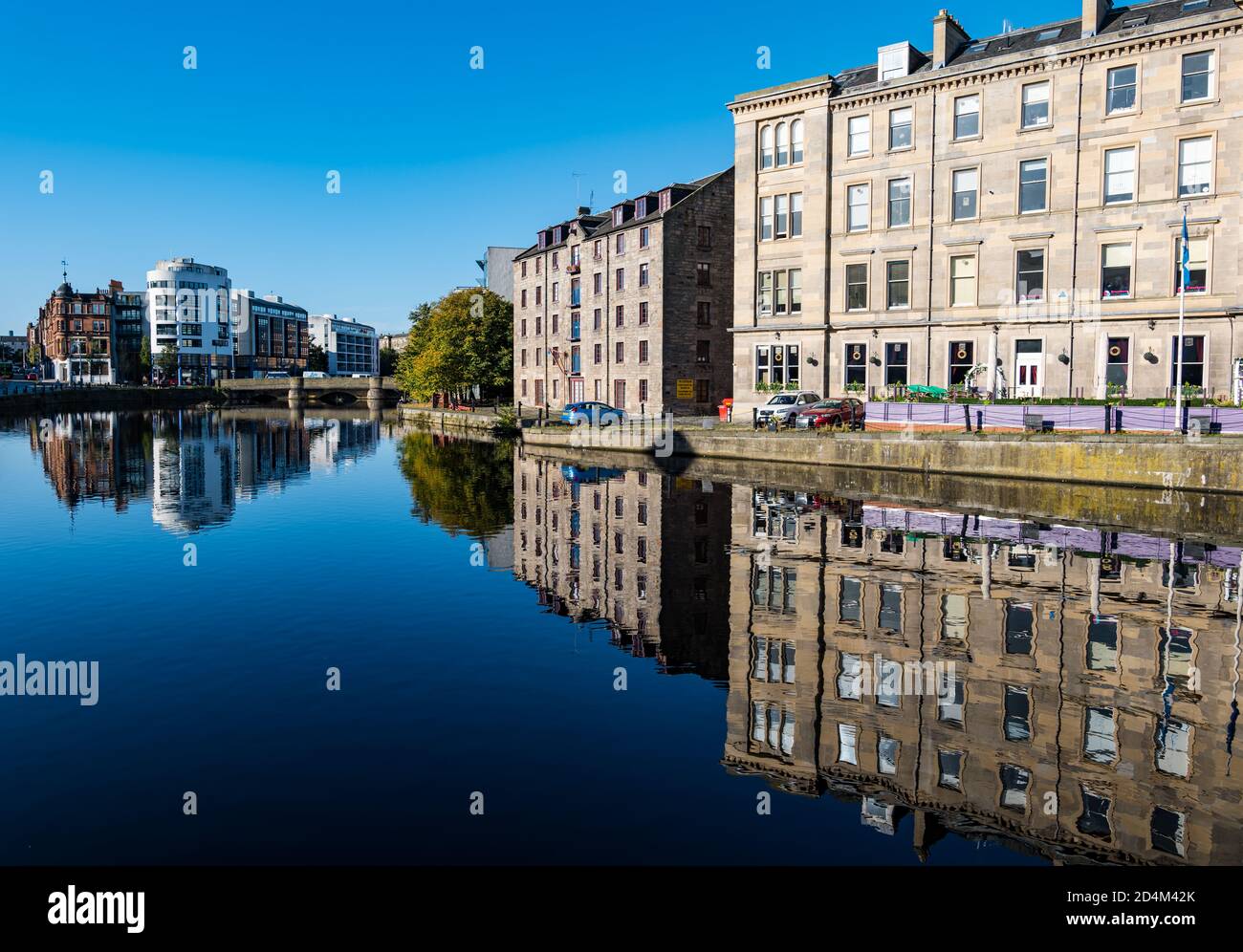 Vecchi edifici sulle acque del fiume Leith al sole che si riflettono nel fiume, la Shore, Leith, Edimburgo, Scozia, Regno Unito Foto Stock