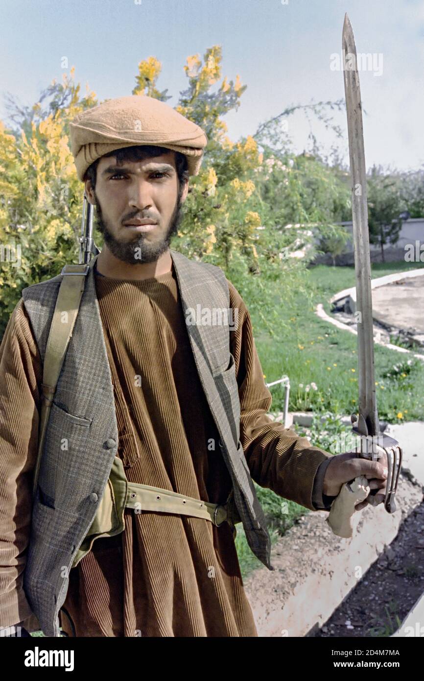 Un guerriero guerriglia afghano mujahideen con gli Hezb-e Islami si pone con la spada durante i combattimenti presso la polizia segreta KHAD nella capitale 15 aprile 1992 a Kabul, Afghanistan. Dopo la sconfitta del governo comunista, i ribelli afghani iniziarono a lottare per il controllo della capitale. Foto Stock