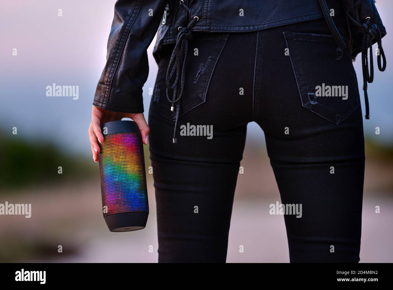 La donna ama ascoltare la musica con gli altoparlanti portatili LED multicolore wireless. Ascoltare la musica all'aperto. Foto Stock