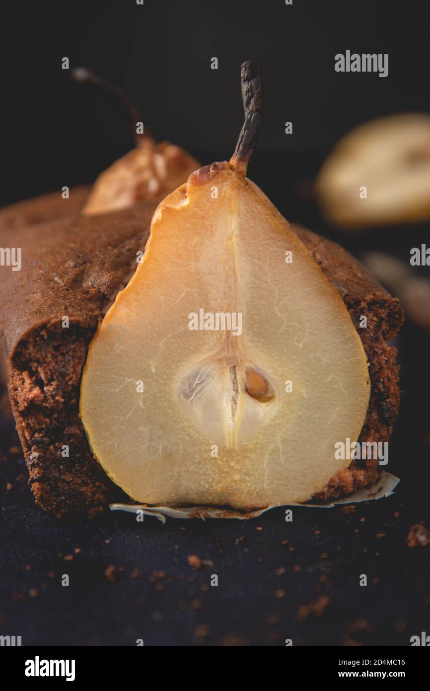Torta di cioccolato vegana fatta in casa con pere in camicia poste su sfondo scuro. Foto Stock