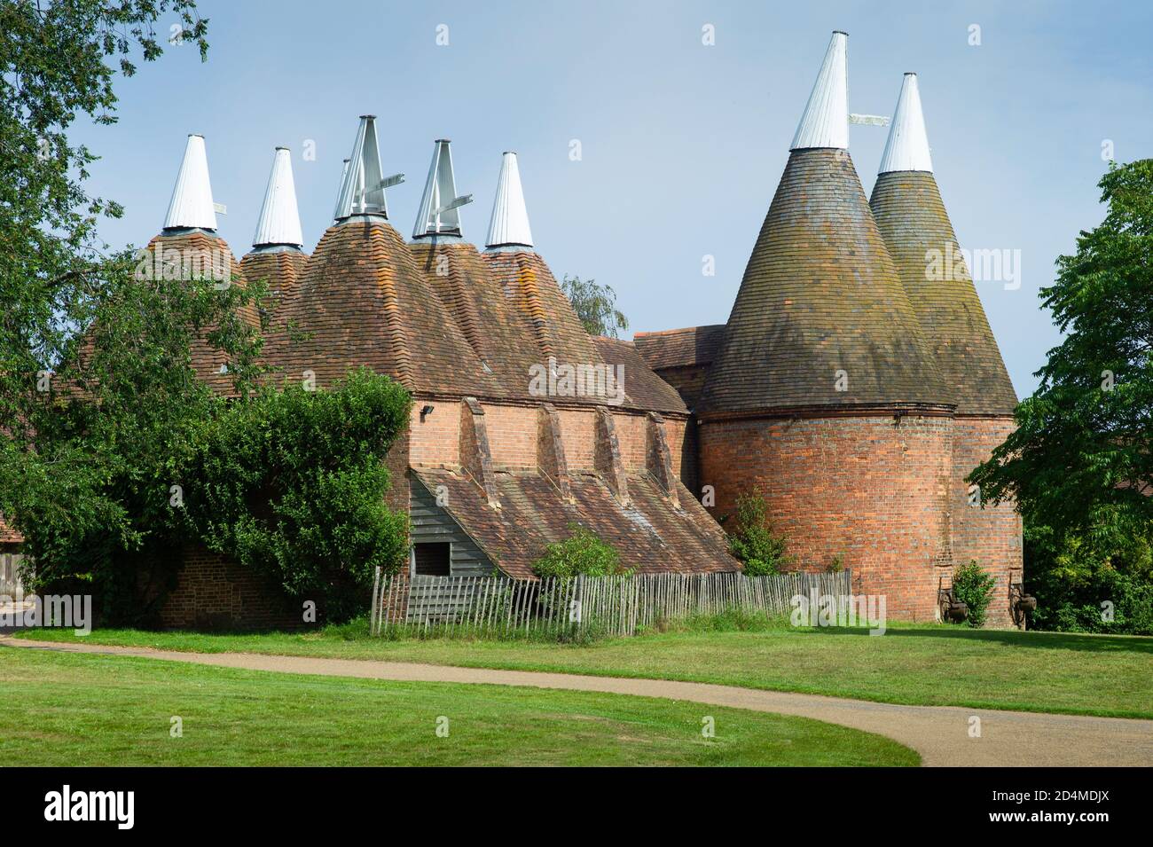 Oast casa edificio progettato per forno (essiccazione) luppolo come parte del processo di produzione. Cielo blu Foto Stock