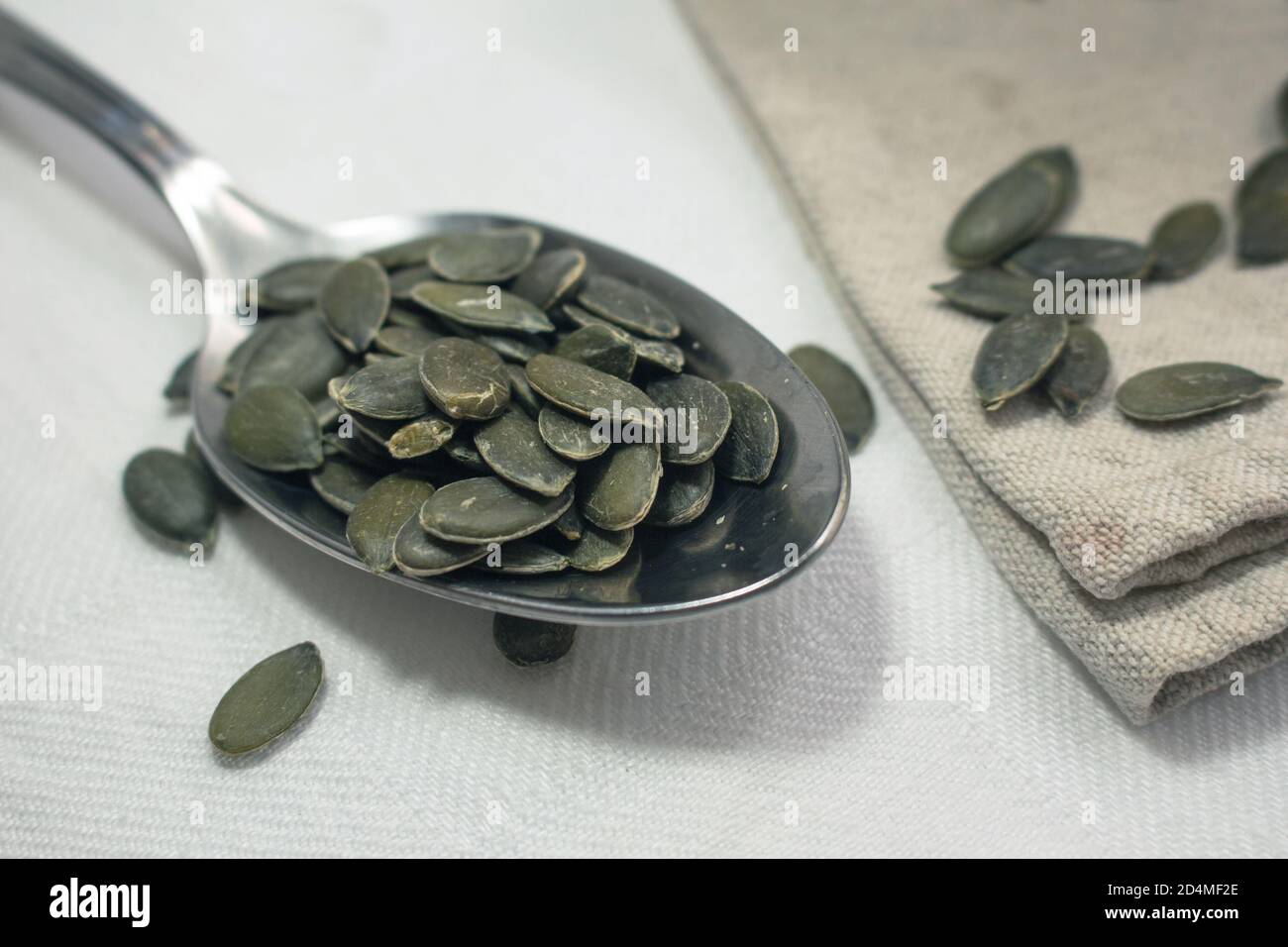 Dettaglio di un cucchiaio pieno di semi di zucca Foto Stock